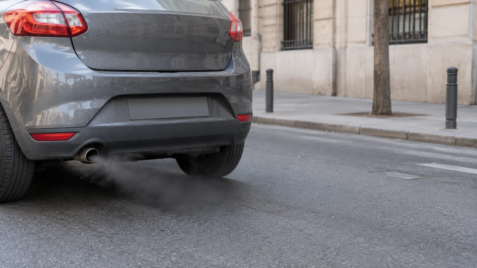 Humo negro diésel saliendo del tubo de escape de un coche en una calle